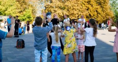 Kyiv, Ukraine 2019.08.24 Children dancing. Little children boys and girls dance in the park with a dance teacher. Childrens and coach pantomime dance in the square. Lots of people at the party