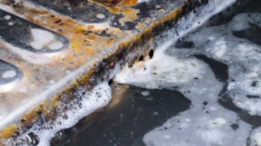 Kirli su kanalizasyona akıyor. Kanalizasyon çelik bir ızgaradan kanalizasyona akar. Yıkandıktan sonra sabunlu su ve yemek artıkları atık borusuna akıyor. Kirli mutfak lavabosu. Pislik ve pislik.
