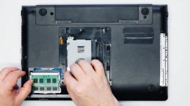 Usta çipi laptoptan çıkarıyor. Elektronik tamirci dizüstü bilgisayardan RAM çipi çıkarıyor. Elektronik ekipman, mikroçip, HDD, anakart tamiri. Servis atölyesi