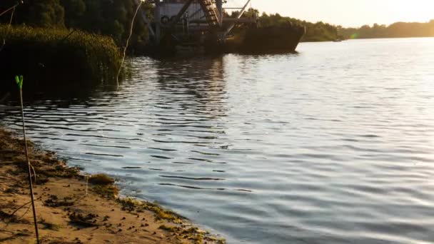 日落时的河流和船只 平静的湖水冲刷着沙滩和芦苇 带工业设备的船在池塘里工作 海滨的蜗牛和海藻 美丽的水景 — 图库视频影像