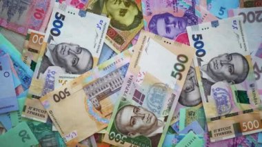 Para masanın üzerinde dönüyor. Üst Manzara. Ağır çekim. Ukrayna ulusal para birimi Hryvnia. Ukrayna parası. Ukrayna Merkez Bankası 'nın banknotları. İş ve finans. Finansal video. Yakın plan.
