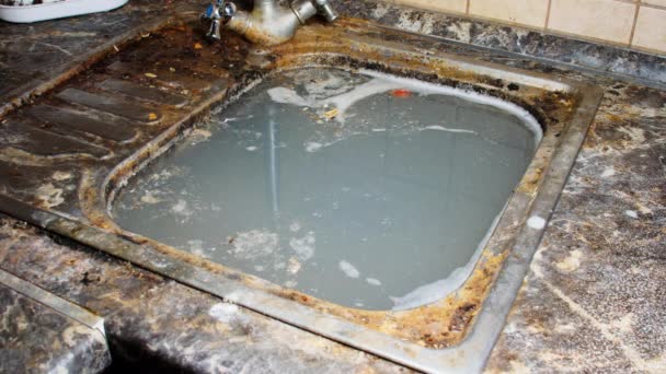厨房的水槽里都是脏水 洗碗后 厨房用肥皂水洗得很脏 肮脏的污水和残剩的食物流入下水道 潮水流入下水道 被污染的厨房 — 图库视频影像
