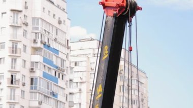 İnşaat alanında seyyar vinç var. Çelik kablo vinçli vinç yelkeni. Güçlü çelik kancalı vinç ve beton levhaları ve ağırlıkları kaldırmak için halatlar. Çok katlı binalar.