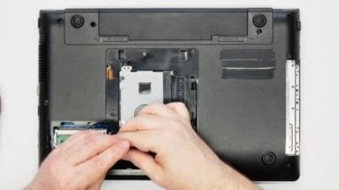 Bir dizüstü bilgisayarı söküyorum. Tamirci sabit diski çıkarır. Uzman elektronik mühendisi vidaları söker ve SSD 'yi bilgisayardan çıkarır. Atölyede garanti tamiri