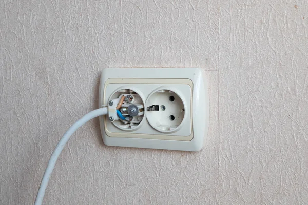 内部に壊れた電気プラグで家庭用コンセント 壁に設置された電気ソケットから突き出た裸線が送電網に接続されている 配線デバイス — ストック写真