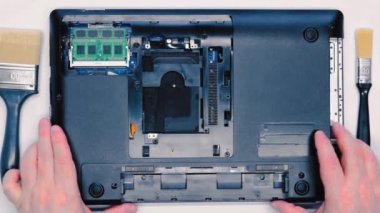 Bir dizüstü bilgisayarı söküyorum. Tamirci bilgisayardaki koruyucu örtüyü kaldırır ve servis merkezinde garanti onarımı için hazırlanır. Tozlu taşınabilir laptop temizlemeye hazır. Üst görünüm