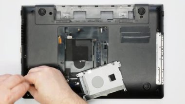Bir dizüstü bilgisayarı söküyorum. Usta vidaları söker. Yakın plan. Bir tamir teknisyeni bilgisayarı söker. Karmaşık elektronik tamiri. Bir atölyede mikroçipler ve diğer bilgisayar parçaları