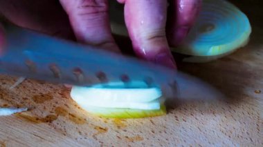 Soğan doğruyorum. Yakın plan. Dilimlenmiş soğan. Sarı soğan. - Yakın çekim. Eller mutfakta soğan doğruyor. Makro beyaz soğan atışı. Adam tahtadan soğan kesiyor..