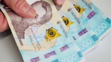 Ukrayna Hryvnia parası. Yeniden hesaplama parası. Erkeklerin elleri 1000 Hryvnia 'nın banknotlarını sayar. Ukrayna Merkez Bankası 'nın kağıt banknotları. Güzel parlak renkli tasarım. Finansal İş Konsepti