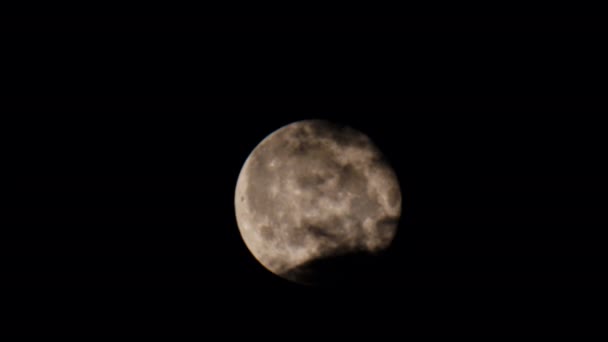 満月を背景に黒い不吉な雲が浮かび上がる 月は徐々に黒い空に浮かんでいます 星のない暗い空に差し迫る美しい月明かりの夜 4K映像 — ストック動画