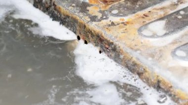 Kirli sabunlu su mutfak lavabosunu boşaltır. Kanalizasyon çelik bir ızgaradan kanalizasyona akar. Yıkandıktan sonra sabunlu su ve yemek artıkları atık borusuna akıyor. Kirli mutfak lavabosu. Pis pislik.