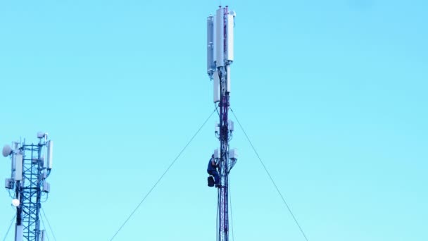 细胞塔修理工 电气工程师在蓝天背景下修理一座移动塔上的能源动力设备 高科技和互联网技术 高塔上有电的电缆 — 图库视频影像