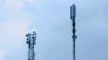 Bulutlu bir gökyüzünün arka planında hücresel antenler. Zaman ayarlı. Hücre Kulesi. Kümülüs bulutlu zaman çizelgesi. Yaz mavisi gökyüzü zaman aşımı. Doğa mavisi gökyüzü. Beyaz bulutlar. Bulut zaman aşımı