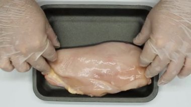 Kümes hayvanları çiftliğinde İşçi Paketleri Tavuk filetosu. Ağır çekim. Tavuk paketliyorum. Tavuk çiftliğindeki tavuk işleme hattı. Tavuk eti üretim hattı. Yiyecek endüstrisi. 4K video görüntüleri. Yakın plan. Üst görünüm