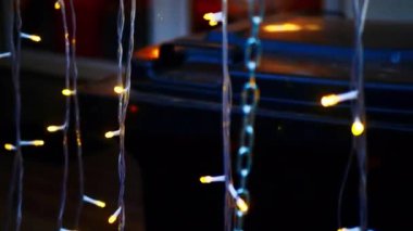 Noel ışıkları. Yanan bir evin arka planına karşı yeni yıl çelengi. Güzel bir Noel geçmişi. Vitrinde bulanık, parlak bir çelenk var. Renkli yeni yıl arkaplanı