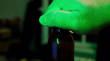 Bira köpüğü açık plastik bir şişeden akar. El renkli ışıkların olduğu bir barda plastik bir bira şişesi açar. Barmen renkli ışık arka planında bir restoranda bir şişe bira açar.