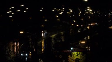 Arabalar yağmurda gece yolu boyunca yol alır. Arabaların farları ve gece lambaları ıslak yola yansıyor. Otoyolda giden araba ve araçların güzel manzarası. Haber için 4k Video