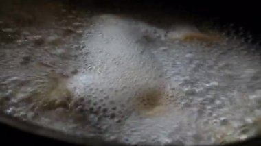 Ravioli suda kaynıyor. Su tencerede kaynıyor. Kaynar su köpükleri. Hamur köfteleri sosta pişirilir. Mutfaktaki ateşte sıcak su kabarcıkları. Lezzetli yemekler hazırlanıyor. Yemek pişir