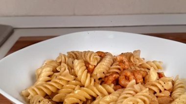 Biber ve baharatlar yavaş yavaş soğan, karides ve domatesle bir tabağa dökülüyor.