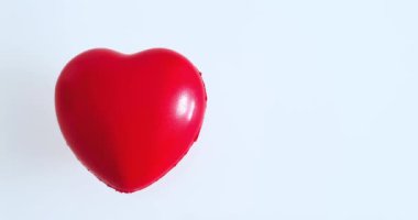 Beyaz arka planda kırmızı kalp sembolü, kalp hastalığı önleme kavramı ve öz bakım ve aşk