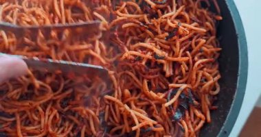 Şef tavada domatesli makarna pişiriyor. Tipik sağlıklı İtalyan yemekleri.