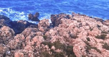 Yaz, deniz dalgalarının mavi gökyüzünün altındaki kayalık sahile düştüğü yerden manzara, tatil ve tatil kavramı, Porto Cesario Lecce