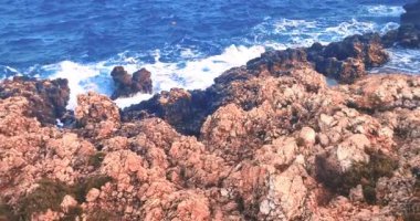 Yaz, deniz dalgalarının mavi gökyüzünün altındaki kayalık sahile düştüğü yerden manzara, tatil ve tatil kavramı, Porto Cesario Lecce