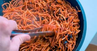 Şef tavada domatesli makarna pişiriyor. Tipik sağlıklı İtalyan yemekleri.