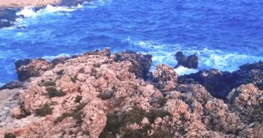Yaz, deniz dalgalarının mavi gökyüzünün altındaki kayalık sahile düştüğü yerden manzara, tatil ve tatil kavramı, Porto Cesario Lecce