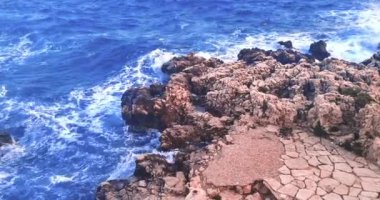 Yaz, deniz dalgalarının mavi gökyüzünün altındaki kayalık sahile düştüğü yerden manzara, tatil ve tatil kavramı, Porto Cesario Lecce