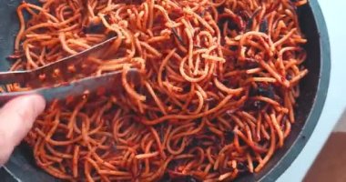 Şef tavada domatesli makarna pişiriyor. Tipik sağlıklı İtalyan yemekleri.