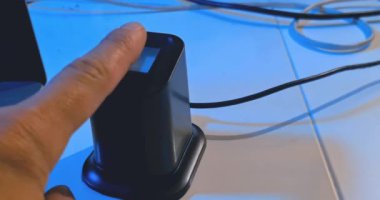 kullanıcı, bir dizüstü bilgisayar, güvenlik ve siber sistem yakınlarındaki bir güvenlik sistemine erişmek için parmak izi okuyucusunu kullanır