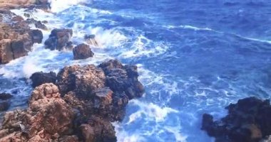Yaz, deniz dalgalarının mavi gökyüzünün altındaki kayalık sahile düştüğü yerden manzara, tatil ve tatil kavramı, Porto Cesario Lecce