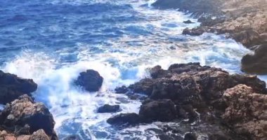 Yaz, deniz dalgalarının mavi gökyüzünün altındaki kayalık sahile düştüğü yerden manzara, tatil ve tatil kavramı, Porto Cesario Lecce