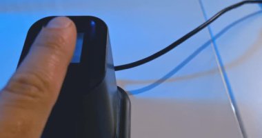 kullanıcı, bir dizüstü bilgisayar, güvenlik ve siber sistem yakınlarındaki bir güvenlik sistemine erişmek için parmak izi okuyucusunu kullanır