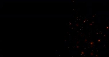 Kamp ateşinden kıvılcımlar saçar. Siyah arka planda kül yükselir. Tehlike patlaması.