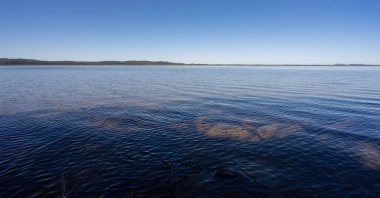 Durgun göl manzarası mavi su, mavi gökyüzü, sükunet, huzur, rahatlama, sakinlik konsepti için kopyalama alanı