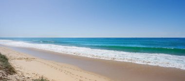 Kumlu sahilde dalgalar kırılıyor. Yaz tatili ya da iş seyahati için kavramsal arka plan. Deniz kumu gökyüzü ufkunun yatay panorama pankartı. İlham verici doğal manzara, güzel, rahatlatıcı tropik plaj manzarası. Sahilde tatil kavramı