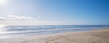 Güneş okyanusun üzerinden doğarken yumuşak pastel sabah renkleri deniz manzarası. Yaz tatili ya da iş seyahati konsepti. İlham verici, güzel, rahatlatıcı deniz manzarası. Kopya alanı olan boş sahil manzarası