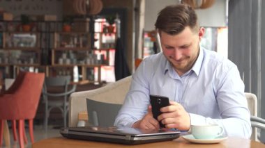 Düzgün bakımlı sakallı şık genç bir işadamı büyüleyici bir kafede otururken derin bir telefon görüşmesi yapar. Gıcır gıcır beyaz bir gömlek giymiş, akıllı telefonunu kendine yakın tutuyor.