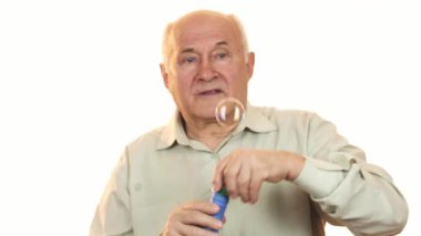 Gri saçlı neşeli yaşlı bir adam kabarcıkları üflerken geniş bir gülümseme sergiliyor ve mutlulukla dolu neşeli bir atmosfer yaratıyor. Kaygısız ruhu, emeklilik sevincinin ve hayatın basit zevklerinin özünü somutlaştırıyor.