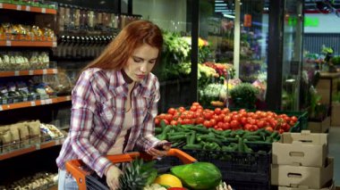Alımlı genç bir çift alışveriş listelerini akıllı bir telefondan kontrol ederken birbirlerine gülümsüyor. Etrafı hareketli bir süpermarkette canlı ürünlerle çevrili. Yakışıklı sarışın adam, güzel kızıl kız arkadaşını sevgiyle kucaklıyor.