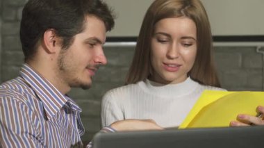 Yakışıklı genç bir iş adamı ve güzel bayan meslektaşı şık ofis çalışma alanlarındaki renkli belgeler hakkında canlı bir tartışmaya girişirler. Odaklanmış ifadeleri ve parlak sarı kağıtları takım çalışmasının enerjisini vurguluyor.