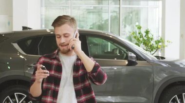 Şık sakallı neşeli bir genç adam telefonda konuşurken heyecandan kıpır kıpır oluyor. Araba anahtarlarını modern bir galeride tutuyor. Arkasındaki parlak, parlak araç neşesini yansıtıyor. Hayatındaki macera dolu yeni bir bölümü sembolize ediyor.