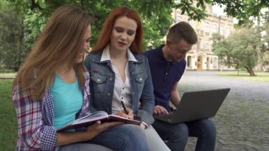 Odaklanmış kahverengi saçlı bir öğrenci egzersiz defterine özenle yazarken, canlı bir kızıl saçlı sınıf arkadaşlarının notlarını ilgiyle izliyor. Yakınlarda, yakışıklı beyaz bir adam dizüstü bilgisayarına yazıp, canlı bir işbirliği ortamı yaratıyor ve...