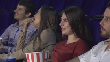 Sıcak bir sinemada, iki çift yan yana oturur, film sihrine boğulurlar. Kırmızı gömlekli kız kameraya ışık saçıyor, patlamış mısırın tadını çıkarırken mutluluk saçıyor ve birlikte güzel anlar paylaşıyorlar.