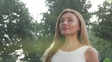 Huzurlu bir kadın, doğal huzuru kucaklayarak canlı yeşil çimenlerin üzerinde zarif bir şekilde nilüfer pozisyonunda oturur. Bu açık hava yoga uygulaması denge ve ahenk yayıyor, huzur ve farkındalık hissi uyandırıyor.