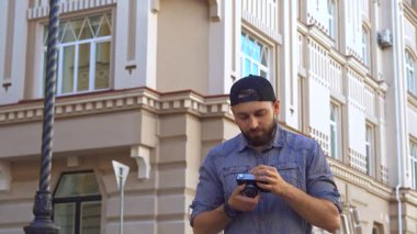 Sıradan bir gömlek ve şapka giymiş şık sakallı bir bisikletçi zarif şehir mimarisinin arka planına karşı fotoğraf çeker. Bu genç Kafkasyalı adam maceranın ruhunu somutlaştırıyor. Eğlenceyi canlı bir şehirde fotoğrafçılığa olan tutkuyla harmanlıyor.