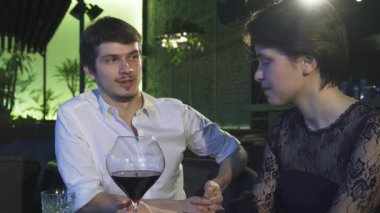 Çekici bir genç adam, hem hoş bir restoranda yumuşak, ortam aydınlatmasıyla aydınlanan çarpıcı kız arkadaşıyla canlı sohbete girişir. Gülüşleri ve bağlantıları büyüleyici bir atmosfer yaratıyor. Aşkı kutlamak için mükemmel.