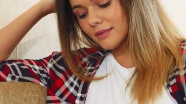 Yumuşak ışıkla dolu rahat bir odada genç bir kadın, rüyalarında kaybolmuş bir kanepede rahatça oturur. Işıl ışıl gülüşü ve rahat duruşu izleyicileri hayal gücünün ve pozitifliğinin huzurlu dünyasına davet ediyor.